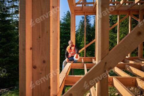 Preview: Carpenter constructing wooden frame house.