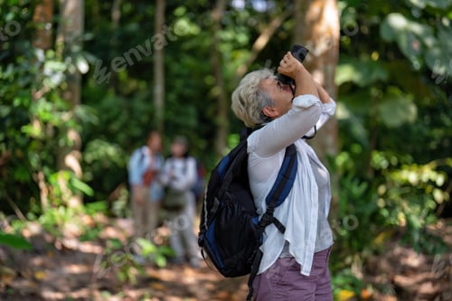 Preview: Backpack tourist travel outdoor adventure bird study using binoculars looking and record to book