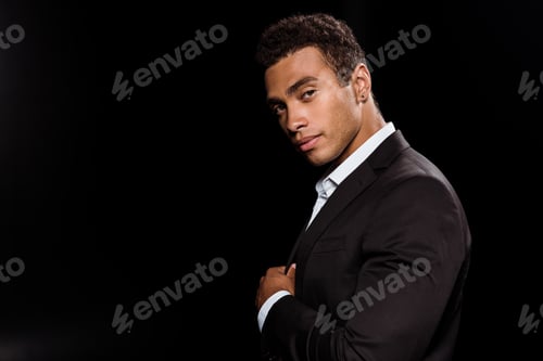Preview: handsome bi-racial man looking at camera isolated on black