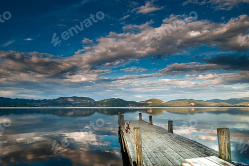 Preview: Mesmerizing landscape of Lake Massaciuccoli with cloudy sky and mountains reflected in water, Italy