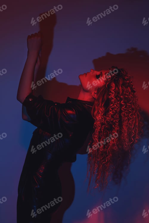 Preview: Young and sexy woman with a stylish Afro hairstyle wearing leather biker suit