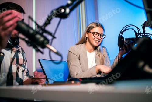 Preview: Young woman and man editing audio podcast in their studio.