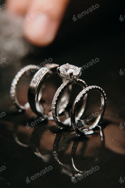 Preview: a close up of three rings with diamond stones on top