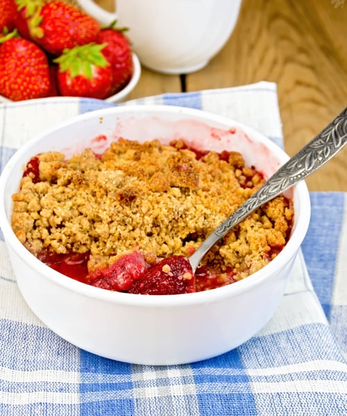 Preview: Crumble strawberry in white bowl on board