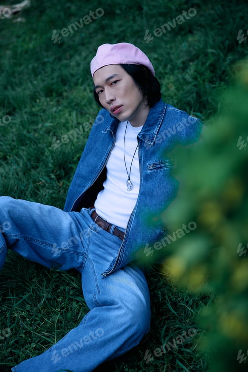Preview: Stylish young man enjoying a sunny day in the park with denim fashion flair
