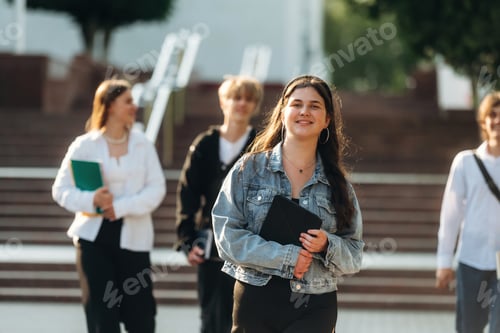 Preview: At sunny day, standing. Group of students are near university together