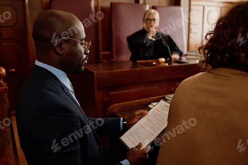 Preview: Focus on young confident attorney reading juridical document in court