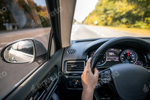 Preview: Woman driver's hands on the steering wheel inside the car.