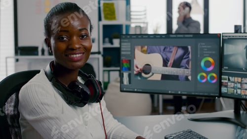 Preview: Close up of african video editor turning head looking at camera smiling
