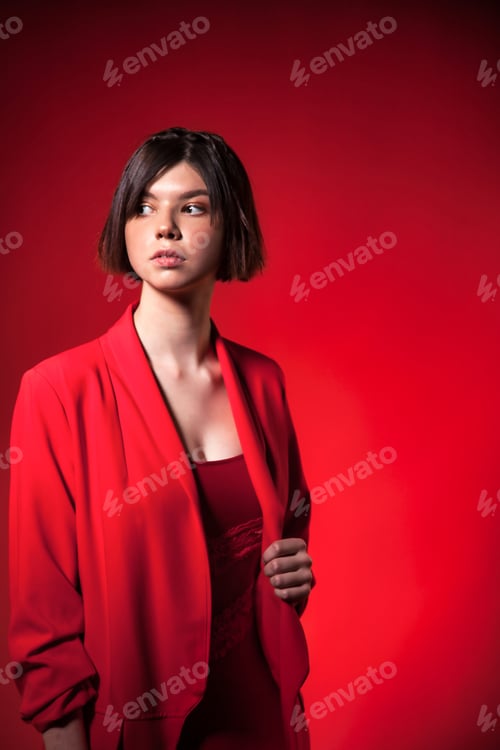 Preview: Portrait teen brunette girl wear trendy red suit with stylish hairstyle at red background