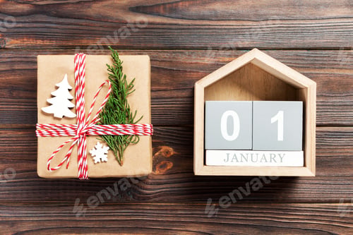 Preview: Christmas calendar 1 january. Christmas gift, fir branches on wooden white background.