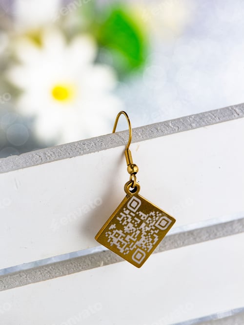 Preview: Closeup of a luxurious, golden earring with a QR code o