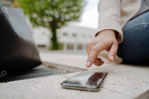Preview: Businesswoman hand using mobile phone touching screen working outdoors, selective focus