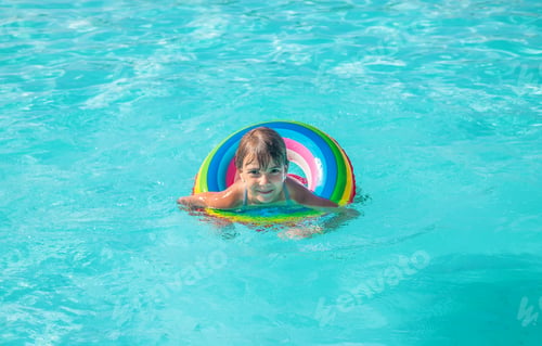Preview: the child swims and dives in the pool. Selective focus.