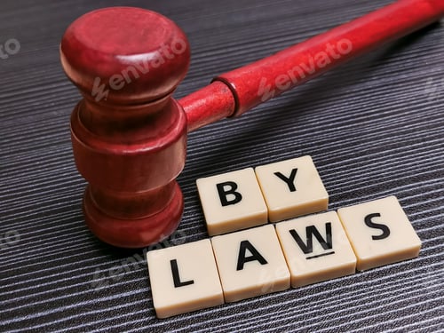 Preview: Word bylaws made from square letter tiles with gavel against black background.