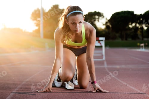 Preview: Young female athlete launching off the start line in a race.