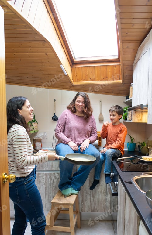 Preview: Family of two lesbian mothers and their son cooking crepes in the kitchen at home