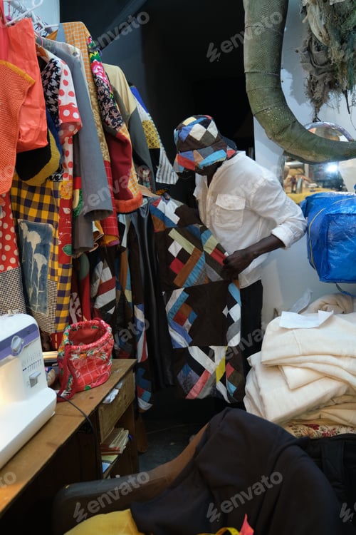 Preview: Black man choosing an african item of clothing to wear.