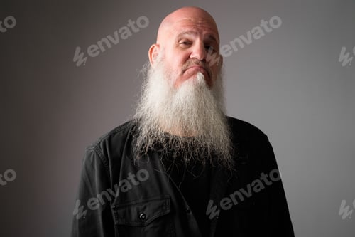 Preview: Face of mature bald man with long beard making smug expression