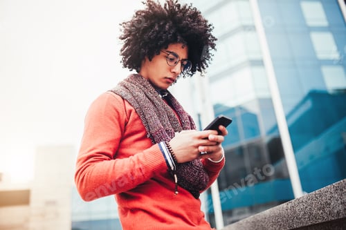 Preview: Mixed race man using smartphone outside