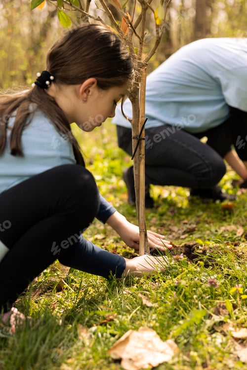 Preview: Young child activist planting a small tree in the ground
