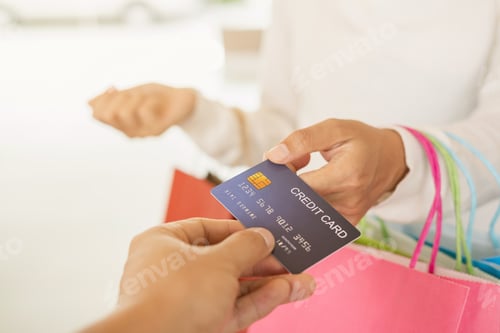 Preview: Young woman with shopping bag using credit card payment