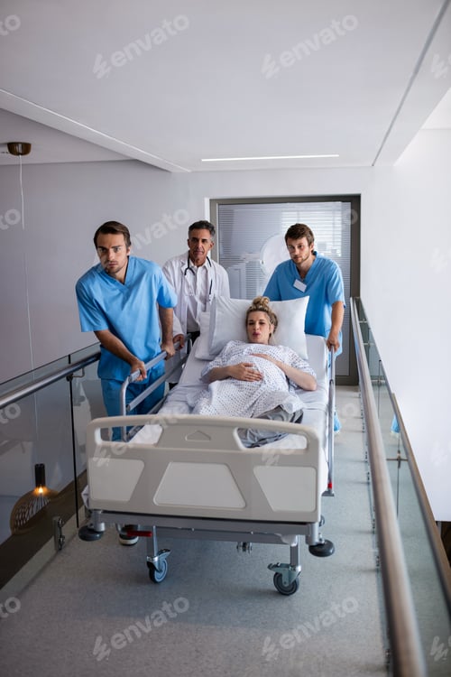Preview: Team of doctors taking a pregnant woman to operation theatre