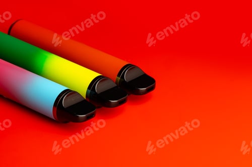 Preview: Disposable electronic cigarettes on red background close up