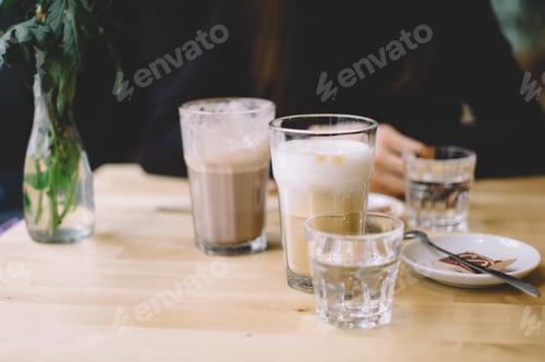 Preview: Hot chocolate and coffee latte with woman in background