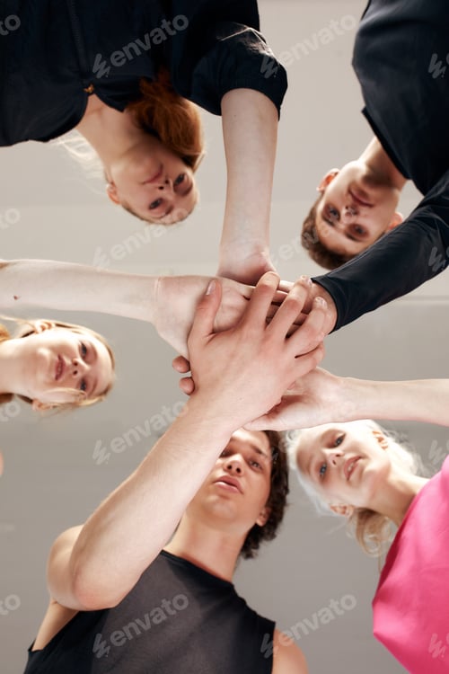 Preview: Team of people holding hands. Group of happy young women holding hands. Bottom view, low angle shot