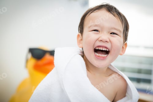 Preview: Mixed Race Boy Having Fun at the Water Park with Large Rubber Duck in the Background.