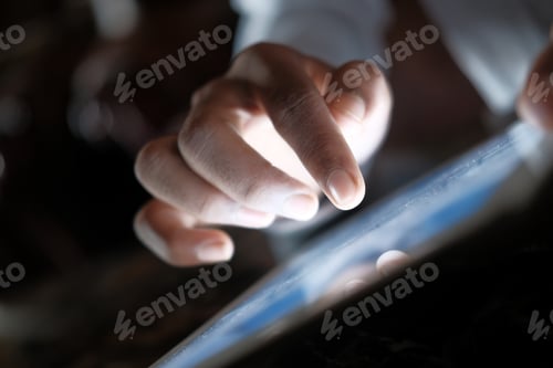 Preview: Close up of man hand using digital tablet at night.