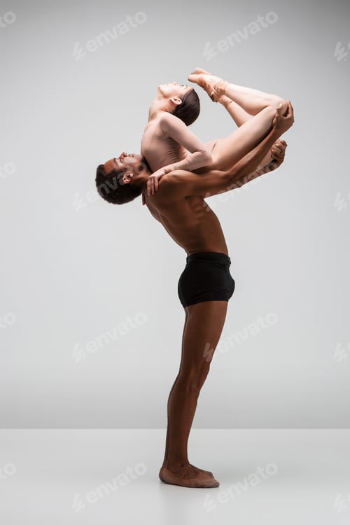 Preview: Couple of ballet dancers posing over gray background