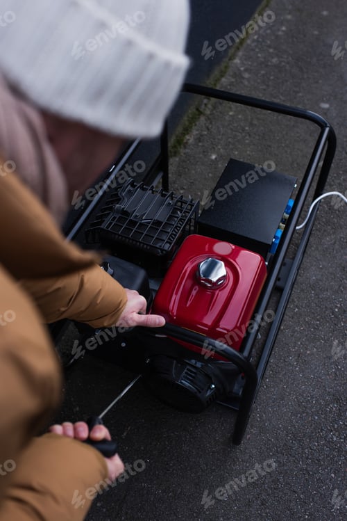 Preview: high angle view of blurred man starting power generator because of electricity blackout