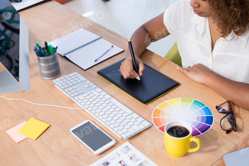 Preview: Female executive working over graphic tablet at her desk