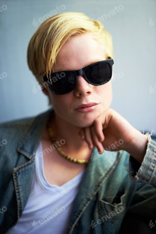Preview: Hes got attitude. Attractive young guy wearing hipster shades with his hand on his chin.