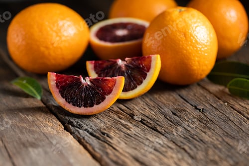 Preview: Sliced Sicilian Blood oranges fruits over old dark wooden background. Top view.