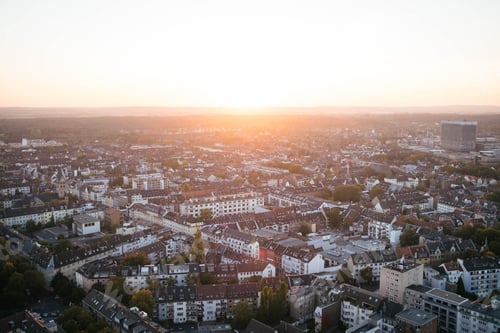 Preview: A horizontal shot of a sunset over a large city. It's summer and the sun is shining in Cologne
