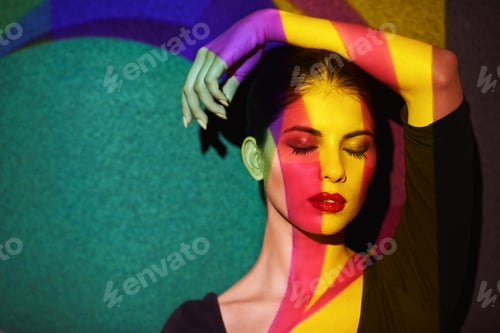 Preview: A beautiful model in the studio covered with a myriad of abstract lighting