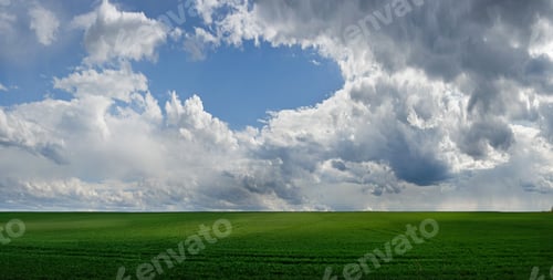 Preview: panoramic view of green field with picturescue sky with clouds at springtime