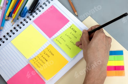 Preview: A student writing notes in a notebook and colored posts