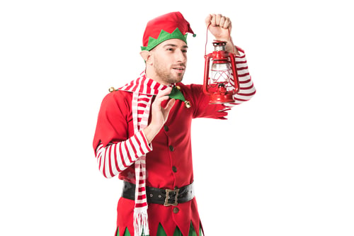 Preview: man in christmas elf costume looking at red lantern isolated on white background