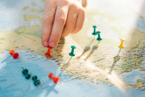 Preview: Cropped view of man with colorful push pins on world map