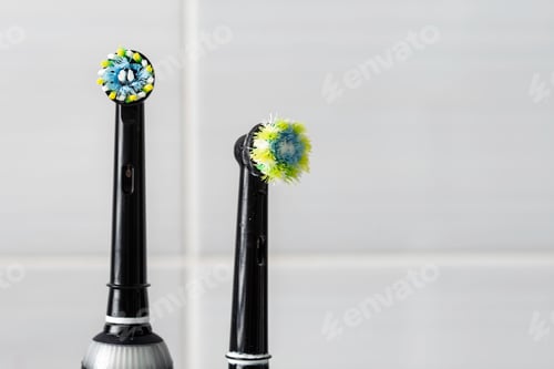 Preview: New electric toothbrush head on black handle contrasts with worn bristles beside