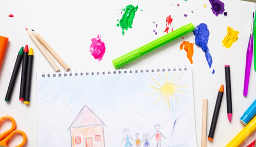 Preview: Colorful paints and family home drawing on white color background, top view