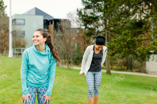 Preview: Two women smiling and walking in a park.