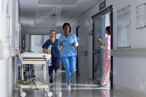 Preview: Diverse doctors wearing scrubs running through corridor at hospital