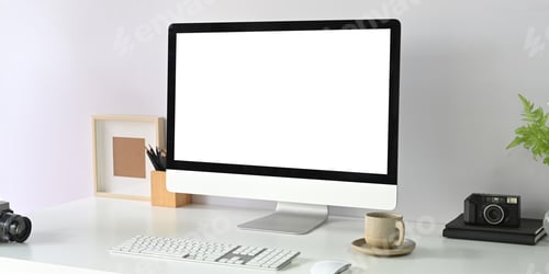 Preview: A blank screen computer monitor is putting on a white working desk surrounded by office equipment.