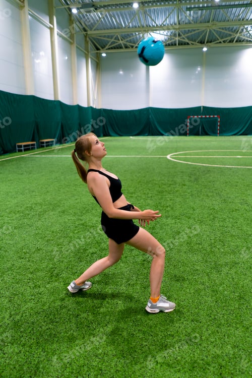 Preview: women's soccer young girl trains coordination on soccer field hitting the ball with her head