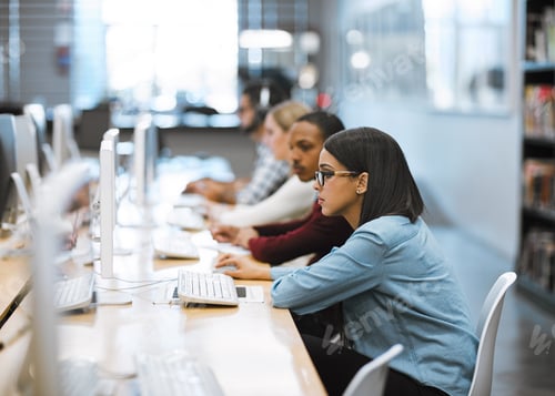 Preview: Shot of a group of university students working on computers in the library at campus